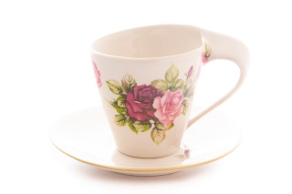 Filiżanka ze spodkiem ozdobiona motywem róży