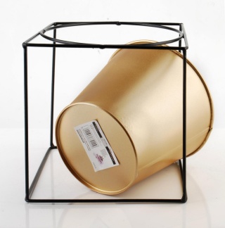 Nowoczesna złota osłonka na czarnym stelażu na doniczkę